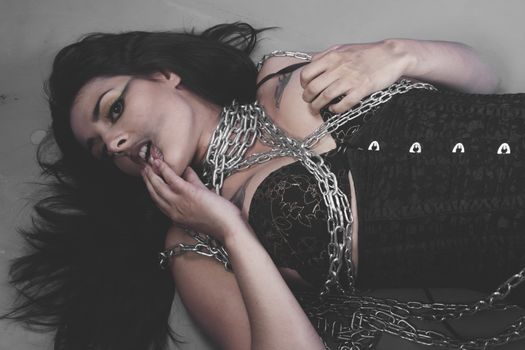 Sadomasochistic, Beautiful brunette woman with big silver chains chained