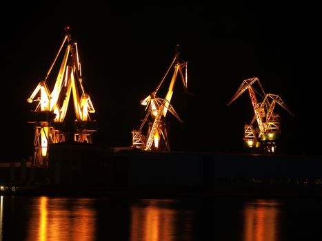 shipyard cranes illumination with reflection, night shot 