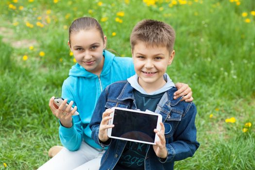 brother and sister with tablet PC and telephone