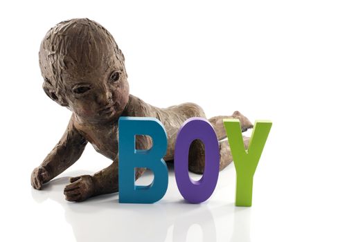 statue of crawlng baby boy made from clay isolated on white