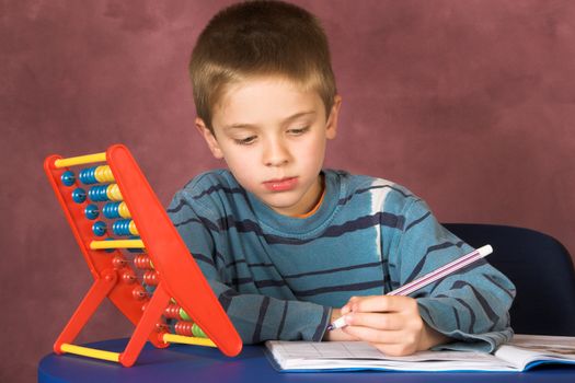 Young boy concentrating on his maths homework