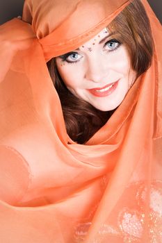 Blue eyed belly dancer with a brightly colored scarf