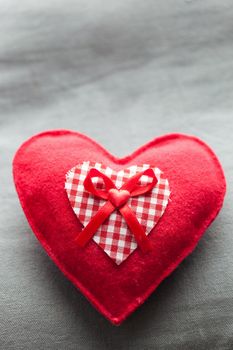 Handmade plush red heart on the soft pillow. Romantic love, Valentine's Day concepts.
