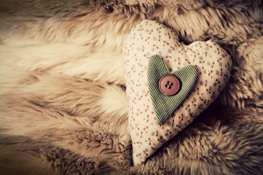 Vintage handmade plush heart on the soft blanket. Romantic love, Valentine's Day concepts.