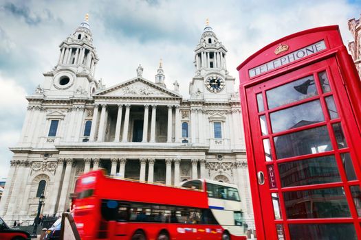 St Paul's Cathedral in London, the UK. Red bus and telephone booth, cloudy sky. Symbols of London