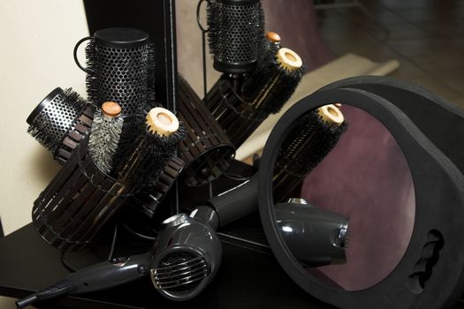 Hair curlers and brushes with mirror on desk