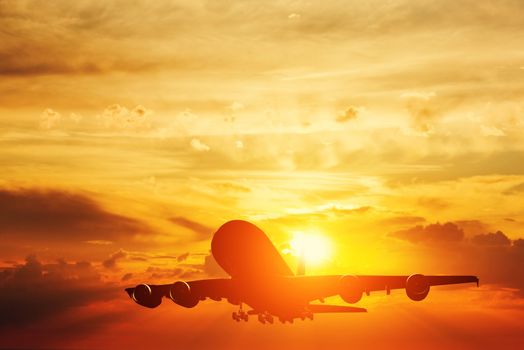 Airplane taking off at sunset. Silhouette of a big passenger or cargo aircraft, airline. Transportation