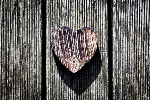 A wooden vintage heart on grunge wood planks. Symbol of love, Valentine's Day