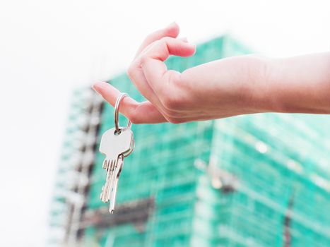 A real estate agent holding keys to a new apartment in her hands. Real estate industry