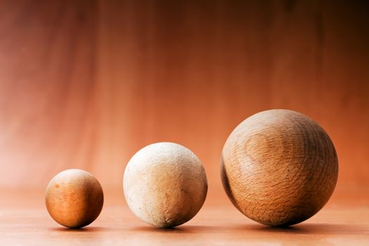 Three wooden balls on a wooden board. Conceptual