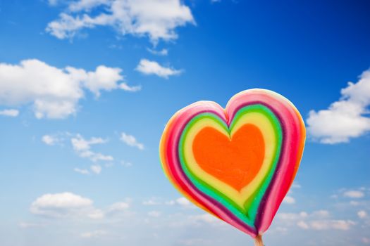 Colorful heart shaped lollipop on sky background. Love, fun, Valentine's day