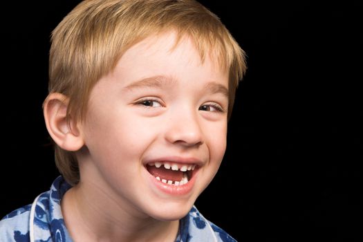 Friendly boy with a blue shirt against a black background