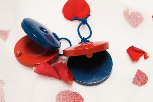 Red and Blue, wooden castanets with rose petals