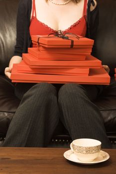 A stack of red gift boxes, the top one tied with black ribbon