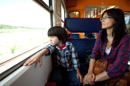 Mother and son travel in the train and look out the window