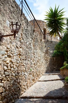 ancient stone paved street and the walls of the medieval fortress