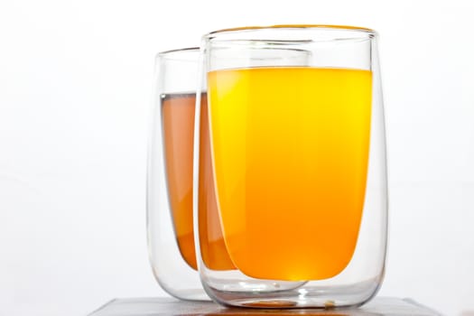 two glasses with drinks on a white background