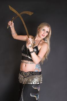 Beautiful Blond Belly Dancer with bronzed tribal swords