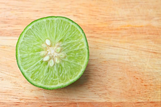 Fresh organic cut limes on wooden cutting board