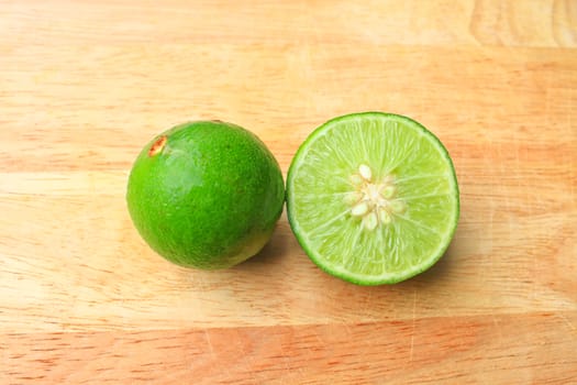 Fresh organic cut limes on wooden cutting board