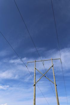 High voltage power transmission lines against blue sky 