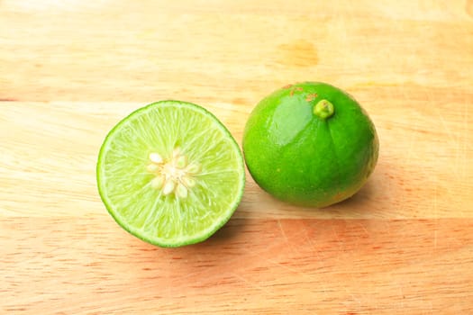 Fresh organic cut limes on wooden cutting board