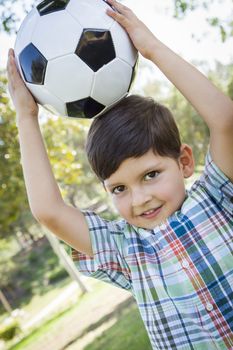 Cute Young Boy Playing with Soccer Ball Outdoors in the Park.