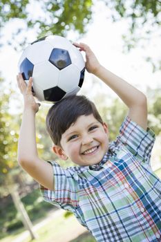 Cute Young Boy Playing with Soccer Ball Outdoors in the Park.