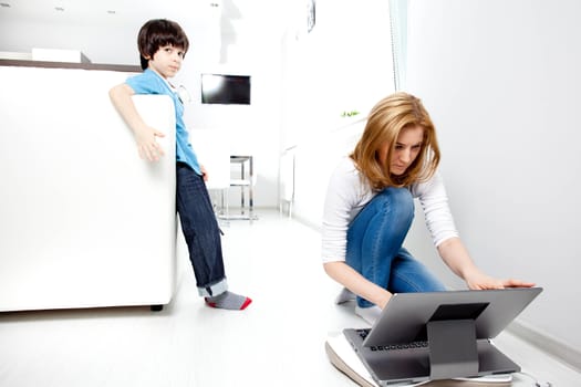 son and mother in the interior of a new home, closing access to adult Web