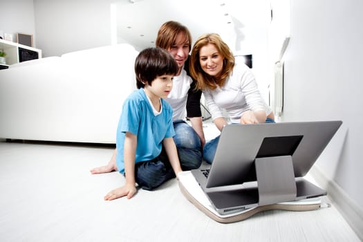 Young parents with child near laptop computer