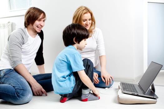 Young parents with child near laptop computer