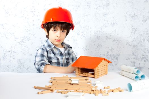 boy builder in red helmet  built a new home