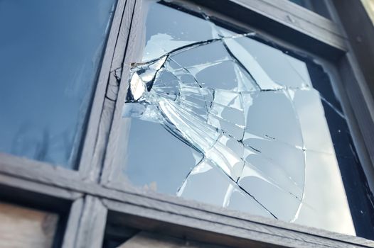 broken glass window reflecting blue sky