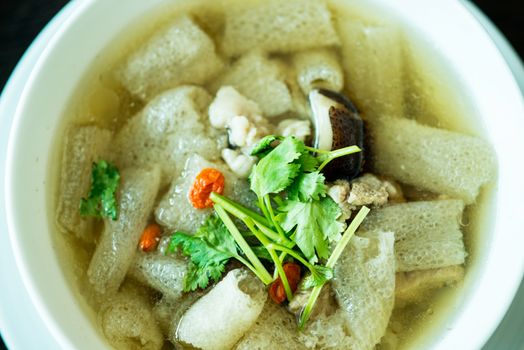 Braised Pork soup with Chinese herb and bamboo in white bowl