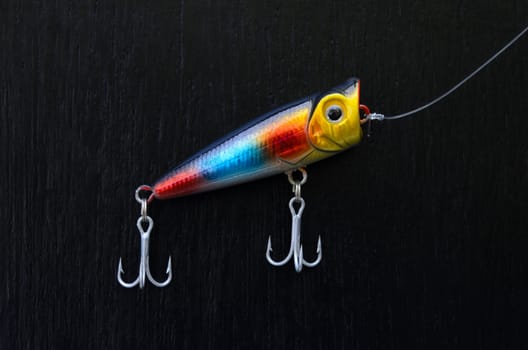 close up of colorful fishing lure on a black board