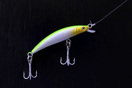 close up of colorful minnow fishing lure on a black board