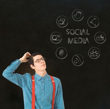 Nerd geek businessman with computer social media network icons on blackboard background