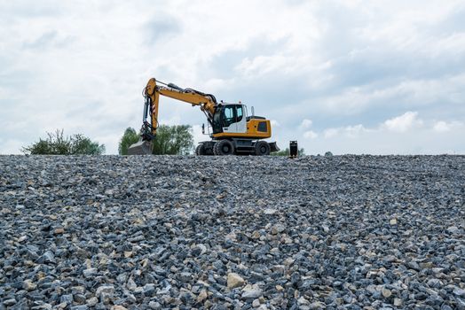 Image of a wheeled excavator on a quarry tip with extra shovel