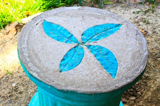 Leaf print on cement chair in garden