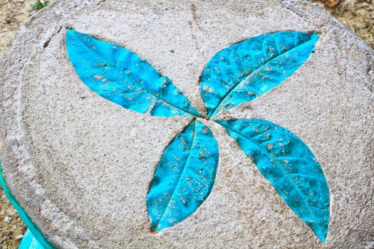 Leaf print on cement chair in garden