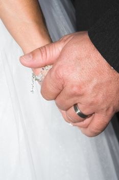 Groom holding his new bride's hand gently