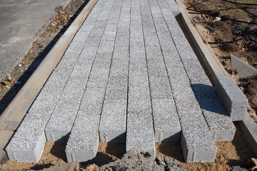 A light gray unfinished brick sidewalk construction