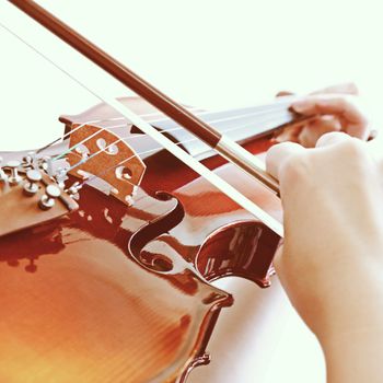 Woman playing violin with retro filter effect