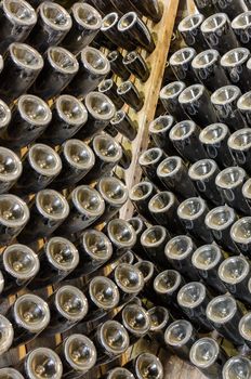 Traditional sparkling wines stored in the rack in cellar of winery