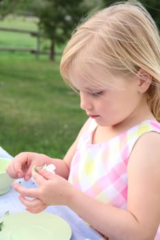 Little blond girl playing with apple blossoms