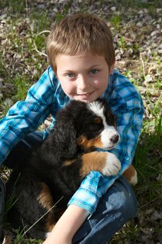 Young boy with his Bernese Mountain Dog puppy