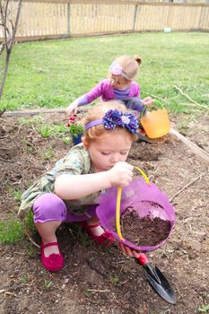 Two sisters planting new flowers in the garden