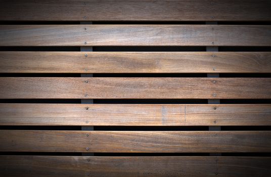 Wooden background with five brown and white boards and screws on black background