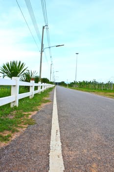 Long  private, country road along a white picket fence