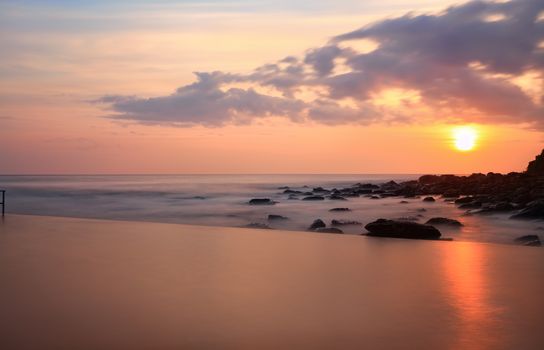 A tranquil view over the pool to the ocean at sunrise, NSW, Australia.  Long exposure